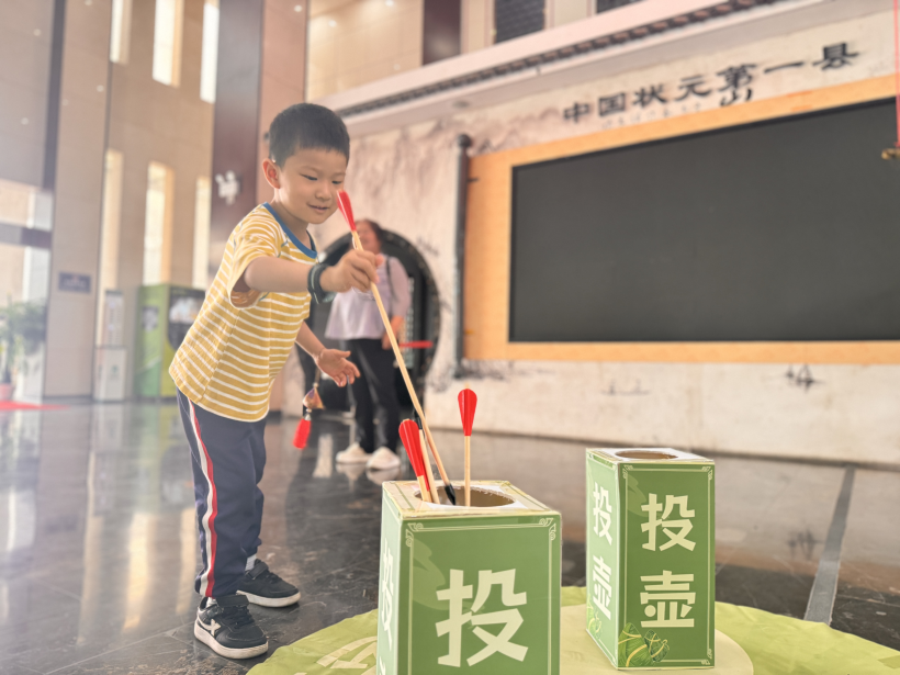 5月31日，一名小旅客在休宁服务区参与传统投壶游戏.jpg